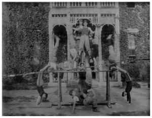 Students making a pyramid, some doing handstands on the ground, a bar, and others being held up by each other