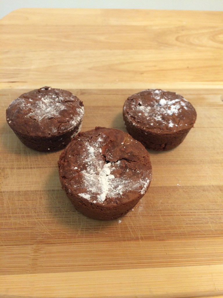 Three round luscious brownies topped with powdered sugar.