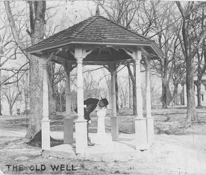 A man drinking from the drinking fountain in the old well circa 1924