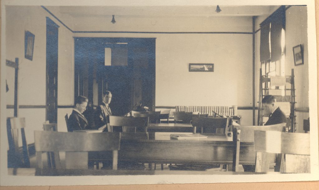 Three students at a table in the Carnegie Library (now Carnegie Guest House), circa 1916.