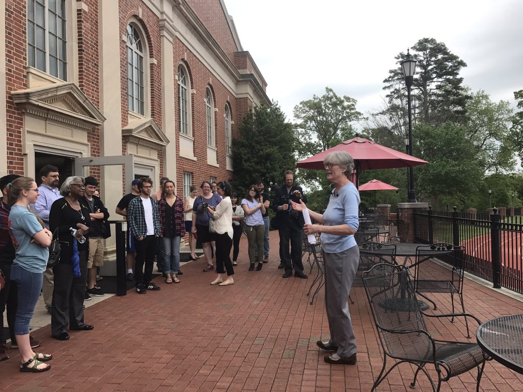 Jan addresses the crowd at her final campus history tour outside of the union on the patio facing the football field in April 2017