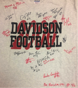A grey t-shirt with black and red text, reading "Davidson Football 2000". Perfect season. Red and black signatures of Senior football players.